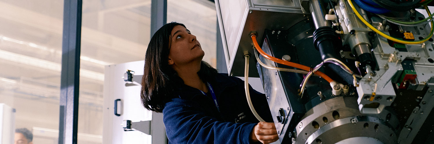 factory worker adjusting machine