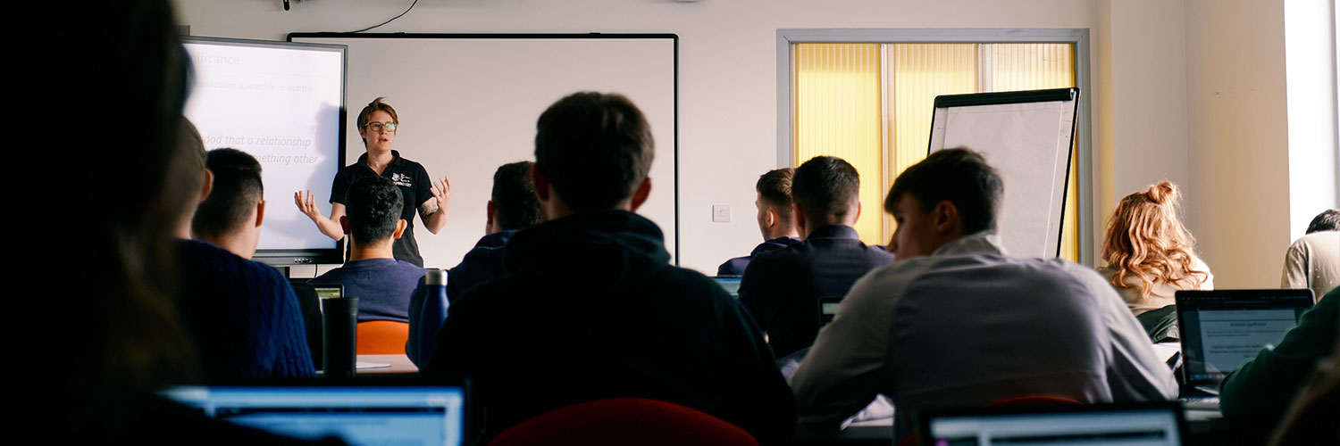 adult learning lecture with teacher at whiteboard presenting to class