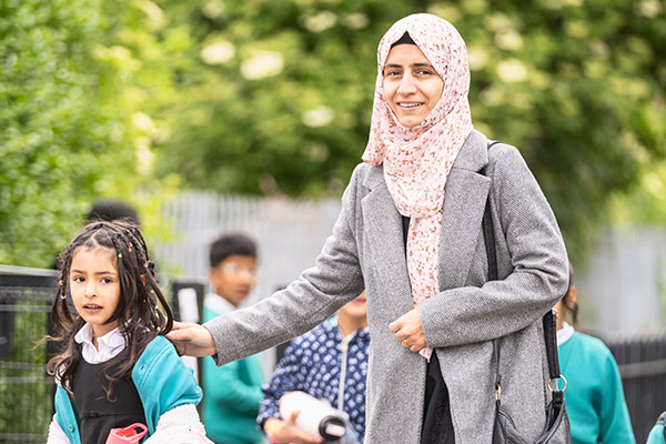 A mother walking her female child to school