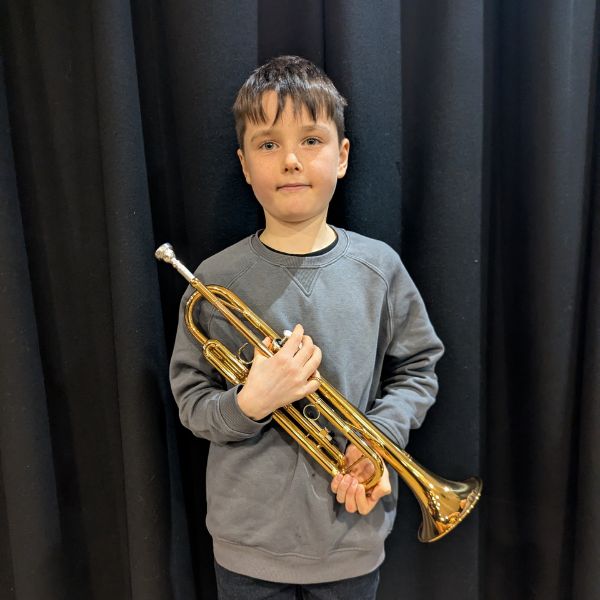 Child holding a brass trumpet